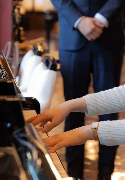 Khách hàng thử đàn piano tại showroom cùng tư vấn viên